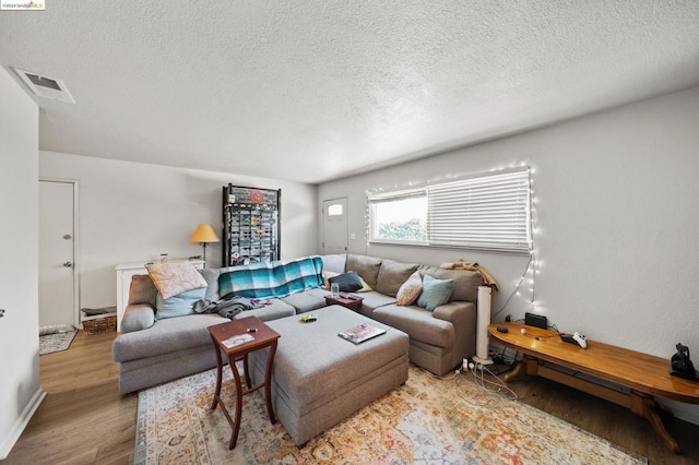 living room with a textured ceiling and light hardwood / wood-style flooring