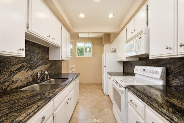 kitchen featuring white appliances, dark stone counters, sink, tasteful backsplash, and white cabinetry