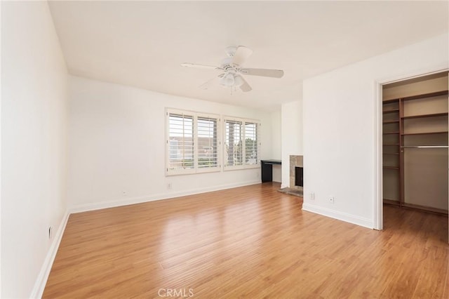 unfurnished living room featuring ceiling fan and light hardwood / wood-style flooring