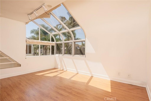 unfurnished room featuring wood-type flooring and track lighting