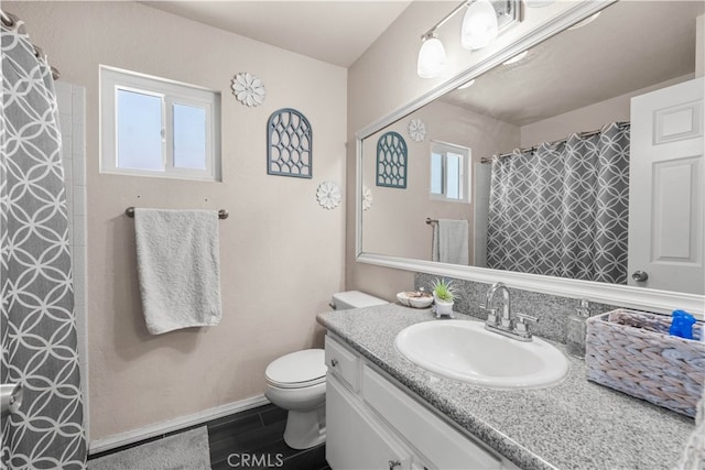 bathroom featuring vanity, toilet, hardwood / wood-style flooring, and a wealth of natural light