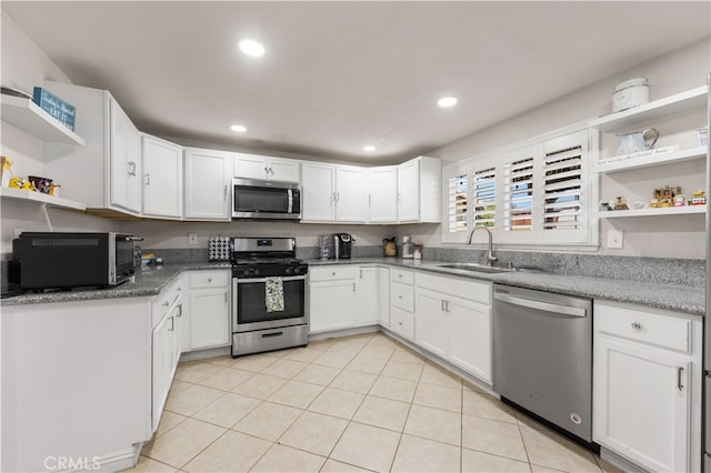 kitchen featuring white cabinetry, light tile patterned floors, appliances with stainless steel finishes, and sink