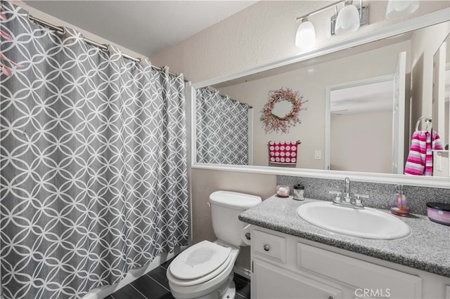 bathroom with toilet, curtained shower, and vanity