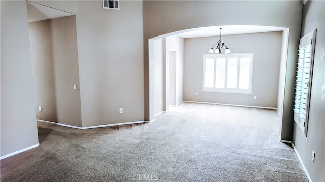 unfurnished room with an inviting chandelier and carpet flooring