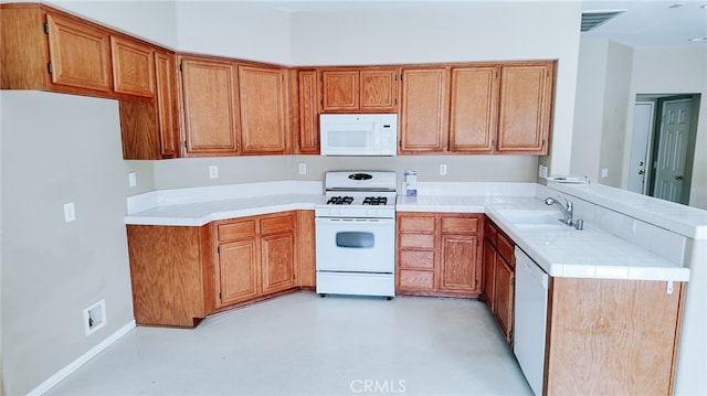 kitchen with white appliances, sink, and kitchen peninsula