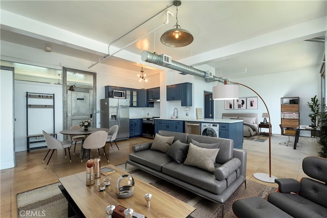 living room featuring washer / dryer and sink