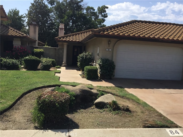 mediterranean / spanish house featuring a garage and a front yard