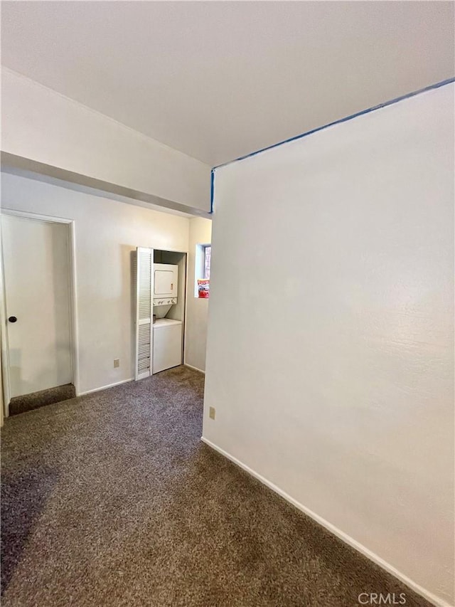 unfurnished room featuring dark colored carpet