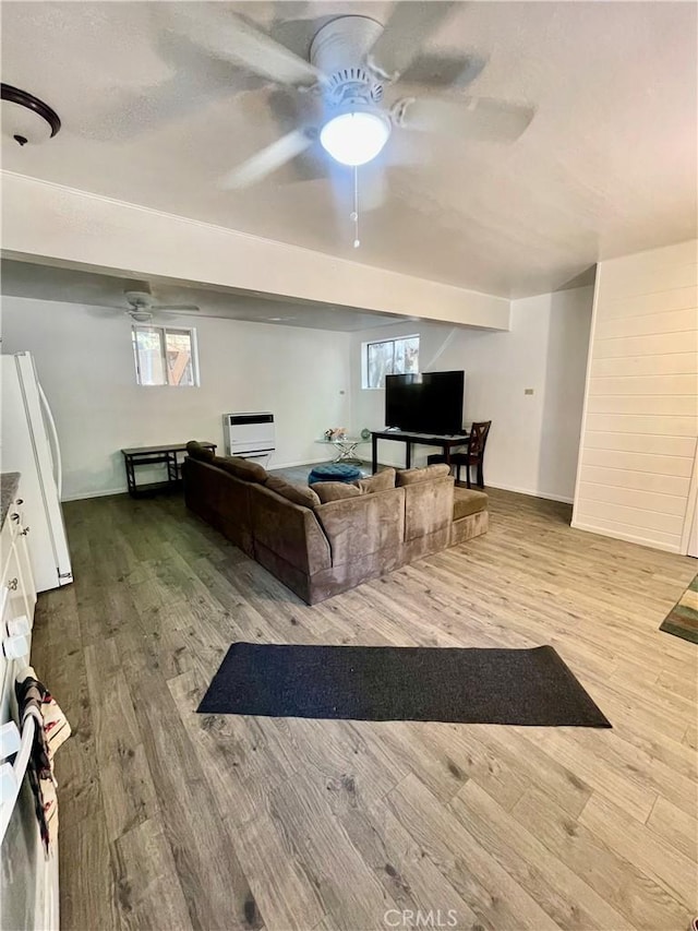 living room featuring hardwood / wood-style flooring, ceiling fan, and heating unit