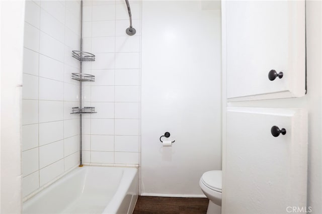 bathroom with wood-type flooring, tiled shower / bath combo, and toilet