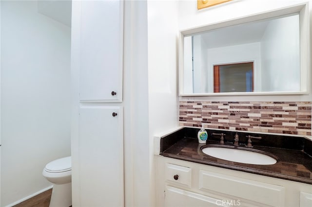 bathroom featuring tasteful backsplash, vanity, and toilet