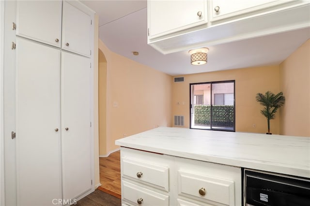 kitchen featuring wood-type flooring and white cabinetry