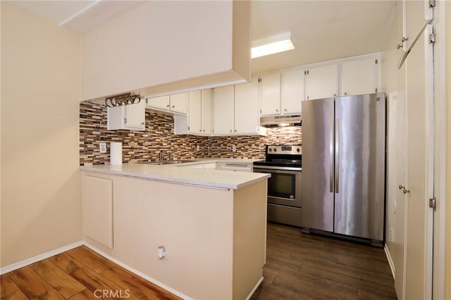 kitchen featuring white cabinets, sink, kitchen peninsula, appliances with stainless steel finishes, and dark hardwood / wood-style flooring