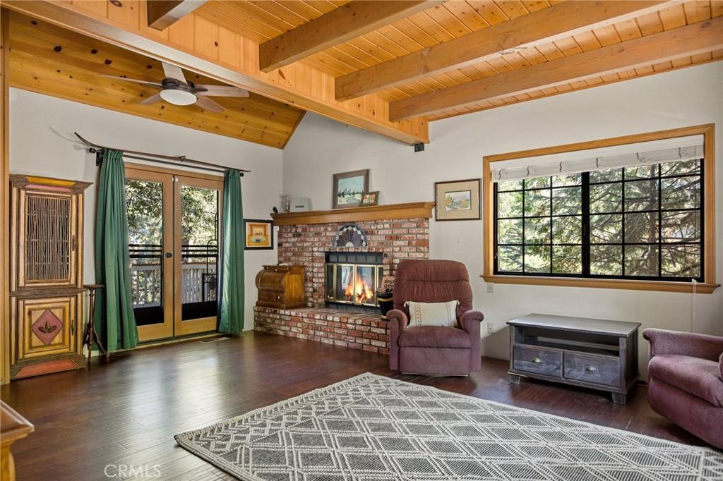 sitting room featuring french doors, ceiling fan, wooden ceiling, a fireplace, and dark hardwood / wood-style floors