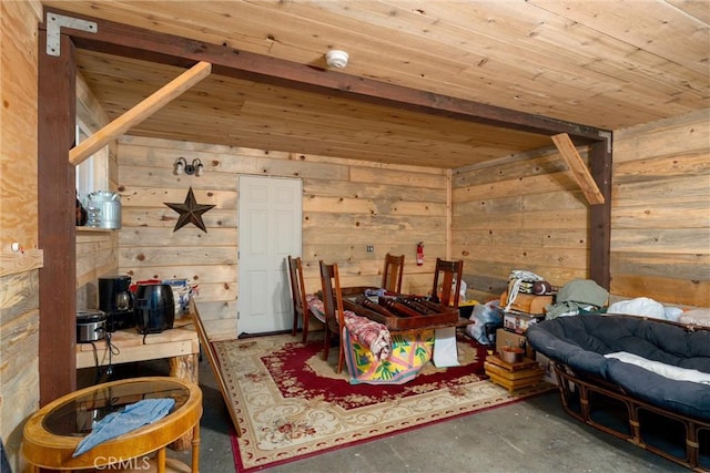 interior space featuring wooden walls, concrete flooring, and wooden ceiling