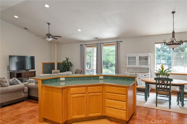 kitchen featuring pendant lighting, ceiling fan with notable chandelier, and a kitchen island