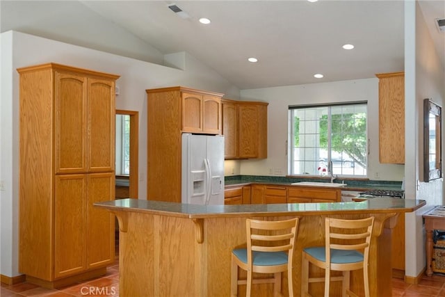 kitchen with white refrigerator with ice dispenser, sink, light tile patterned floors, and kitchen peninsula