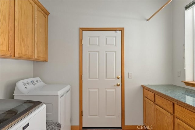 clothes washing area with washing machine and dryer and cabinets