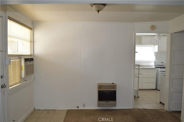 unfurnished room featuring light tile patterned floors, heating unit, and cooling unit