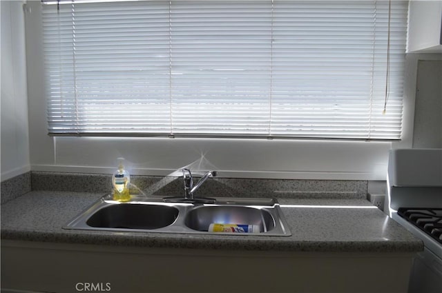 kitchen with white gas stove and sink