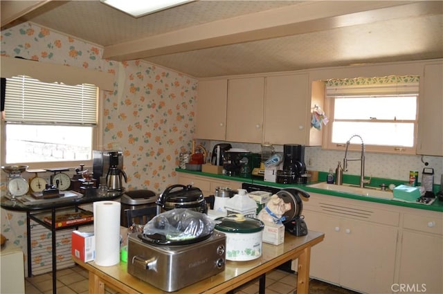 kitchen with tile patterned flooring, white cabinetry, and sink