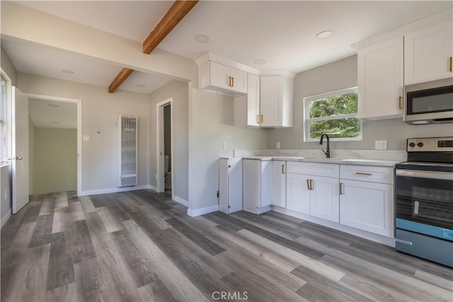 kitchen featuring hardwood / wood-style floors, appliances with stainless steel finishes, and white cabinets