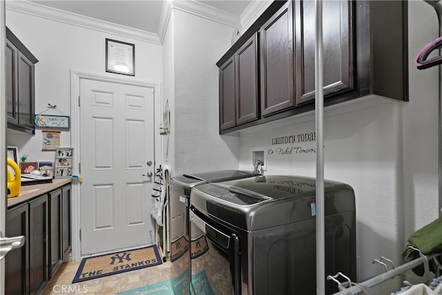 laundry area featuring washer and clothes dryer, cabinets, and crown molding