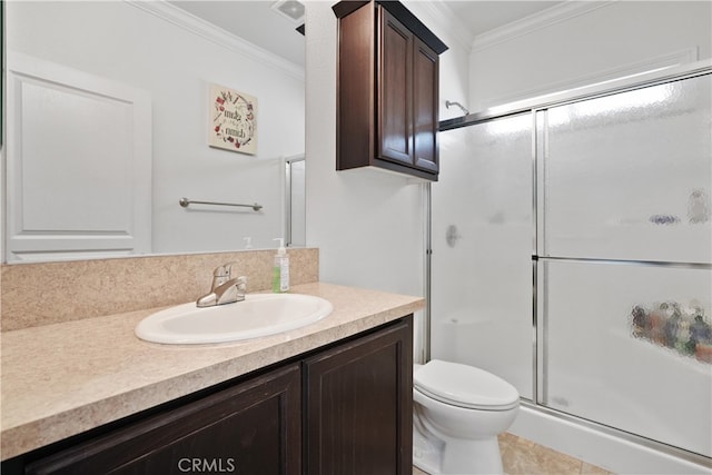 bathroom featuring ornamental molding, vanity, toilet, and a shower with door