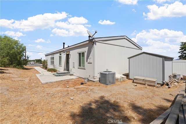 back of house featuring a storage unit and central AC