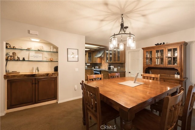 carpeted dining area with an inviting chandelier