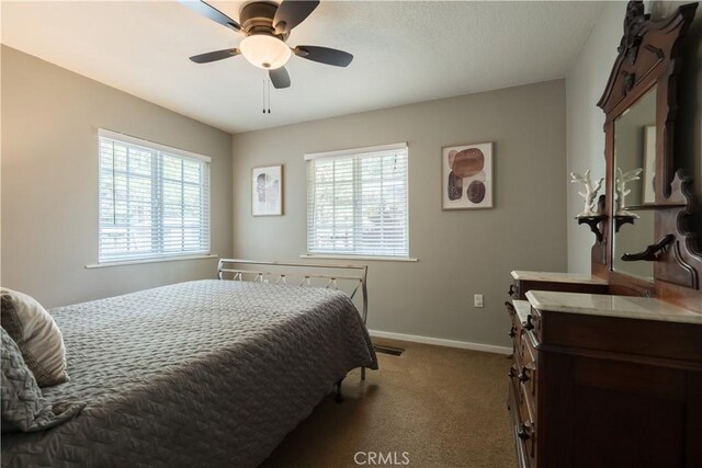 carpeted bedroom with ceiling fan and multiple windows