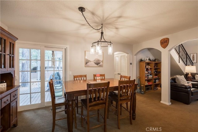 dining room featuring dark carpet and a textured ceiling