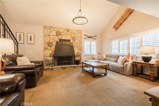 carpeted living room featuring high vaulted ceiling, ceiling fan with notable chandelier, and a fireplace