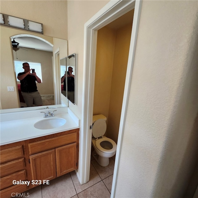 bathroom featuring toilet, vanity, ceiling fan, and tile patterned floors