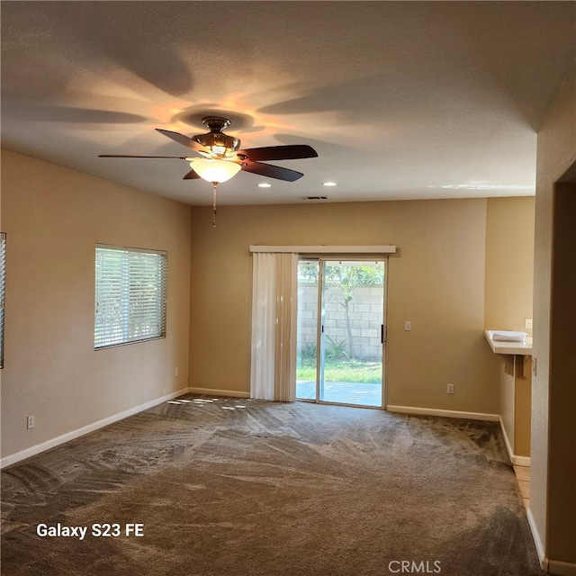 carpeted empty room featuring ceiling fan