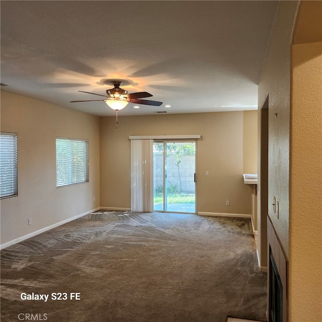 carpeted empty room featuring ceiling fan