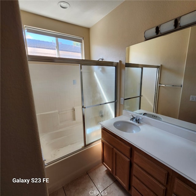 bathroom featuring combined bath / shower with glass door, vanity, and tile patterned flooring