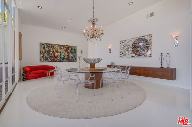 dining room with concrete flooring and a notable chandelier