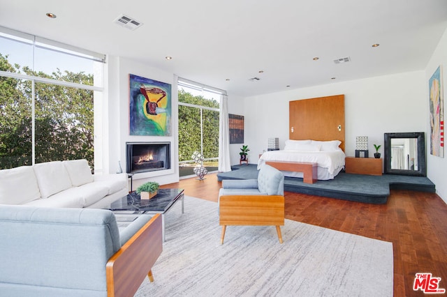 bedroom with hardwood / wood-style floors and a wall of windows