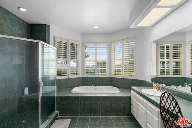 bathroom with tile patterned flooring, a textured ceiling, independent shower and bath, and vanity