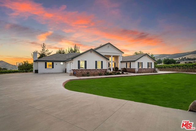 view of front of property featuring a lawn and a mountain view