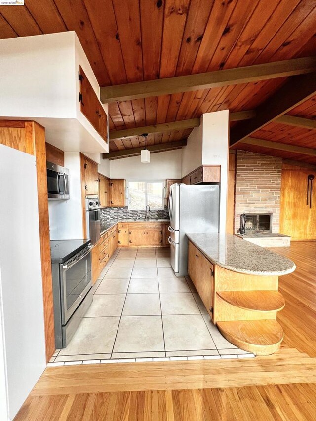 kitchen featuring sink, stainless steel appliances, wooden ceiling, lofted ceiling with beams, and light wood-type flooring