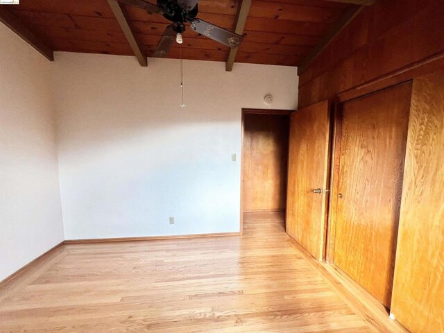 spare room with beam ceiling, light wood-type flooring, ceiling fan, and wood ceiling