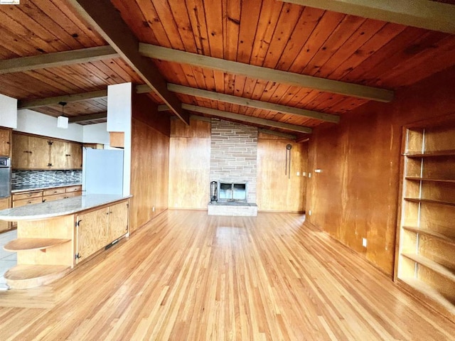 unfurnished living room with wooden ceiling, vaulted ceiling with beams, wood walls, a fireplace, and light wood-type flooring