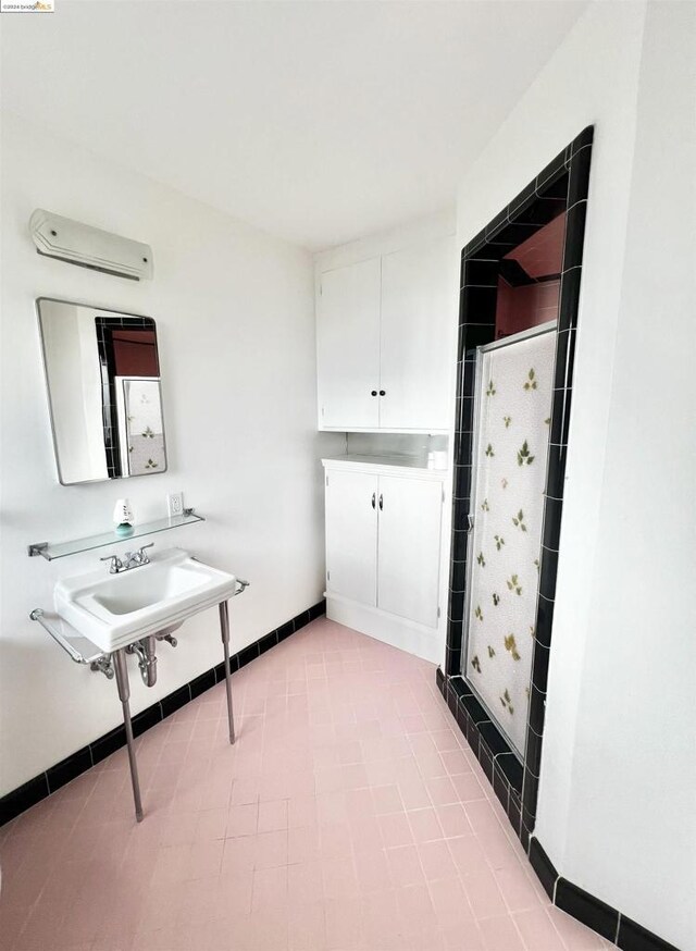 bathroom with tile patterned flooring, a shower, and an AC wall unit