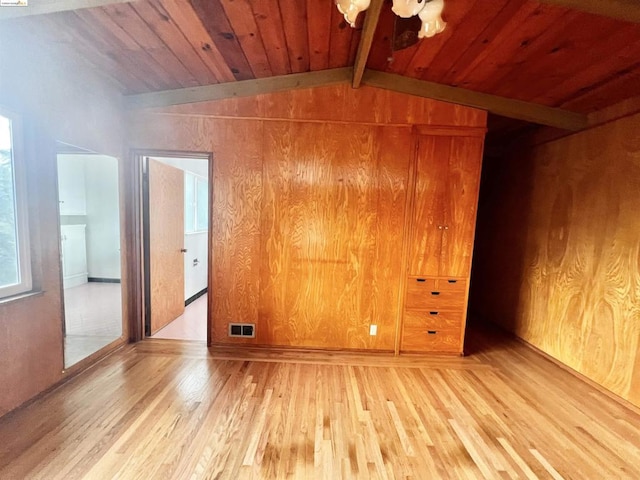 unfurnished room featuring lofted ceiling with beams, wood walls, wood-type flooring, and wood ceiling