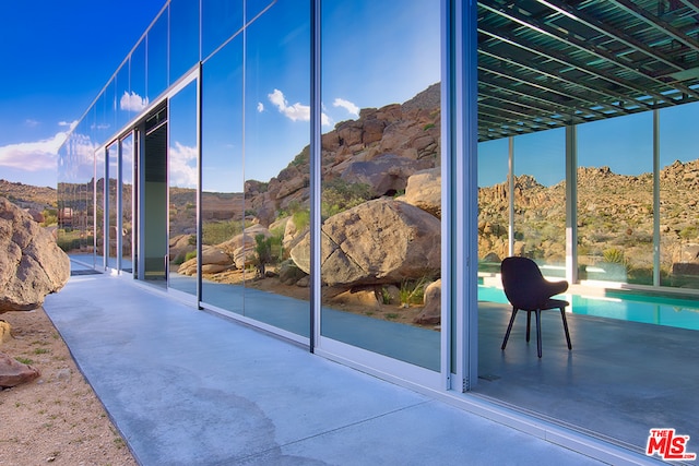 exterior space with concrete floors, a mountain view, and a wealth of natural light