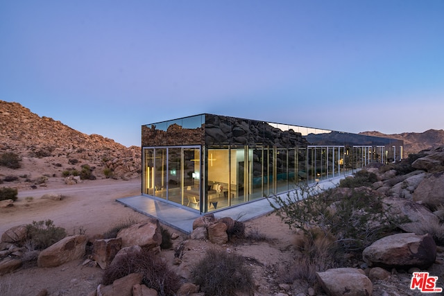 back house at dusk featuring a mountain view