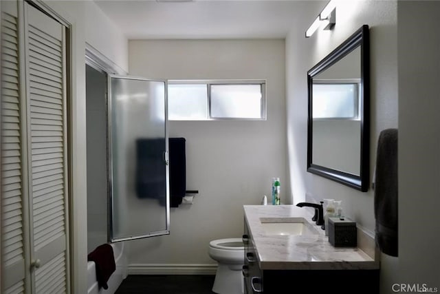 bathroom with vanity, a shower with shower door, and toilet