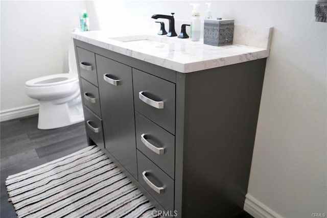 bathroom with hardwood / wood-style floors, vanity, and toilet